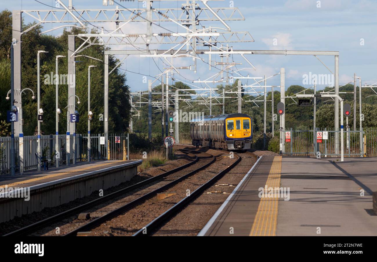 Treno elettrico multiunità Northern Rail classe 319 a Kirkham e Wesham con segnale LED rosso e catenaria Foto Stock