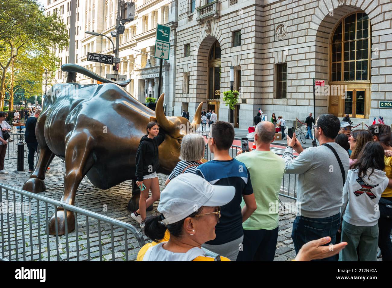 La gente resta in fila per scattare foto alla statua del Toro di ricarica a New York, Stati Uniti. Foto Stock