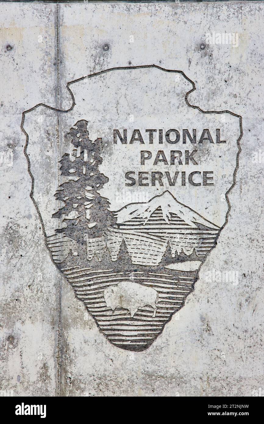 Parete in cemento testurizzato con simbolo del National Park Service incorporato Foto Stock