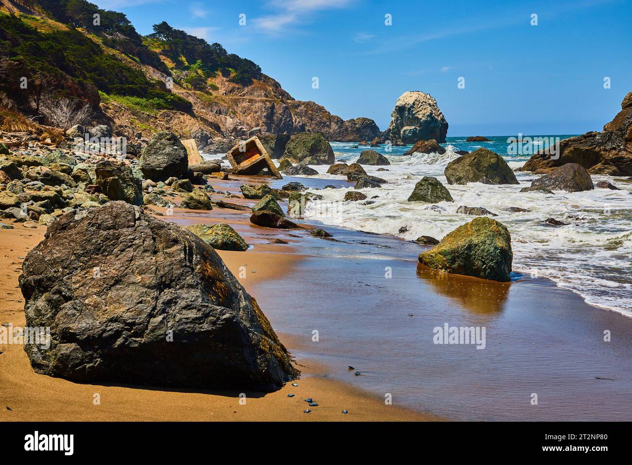 Boulder è disseminata di spiagge con onde oceaniche che si infrangono e strutture in cemento distrutte sulla riva Foto Stock