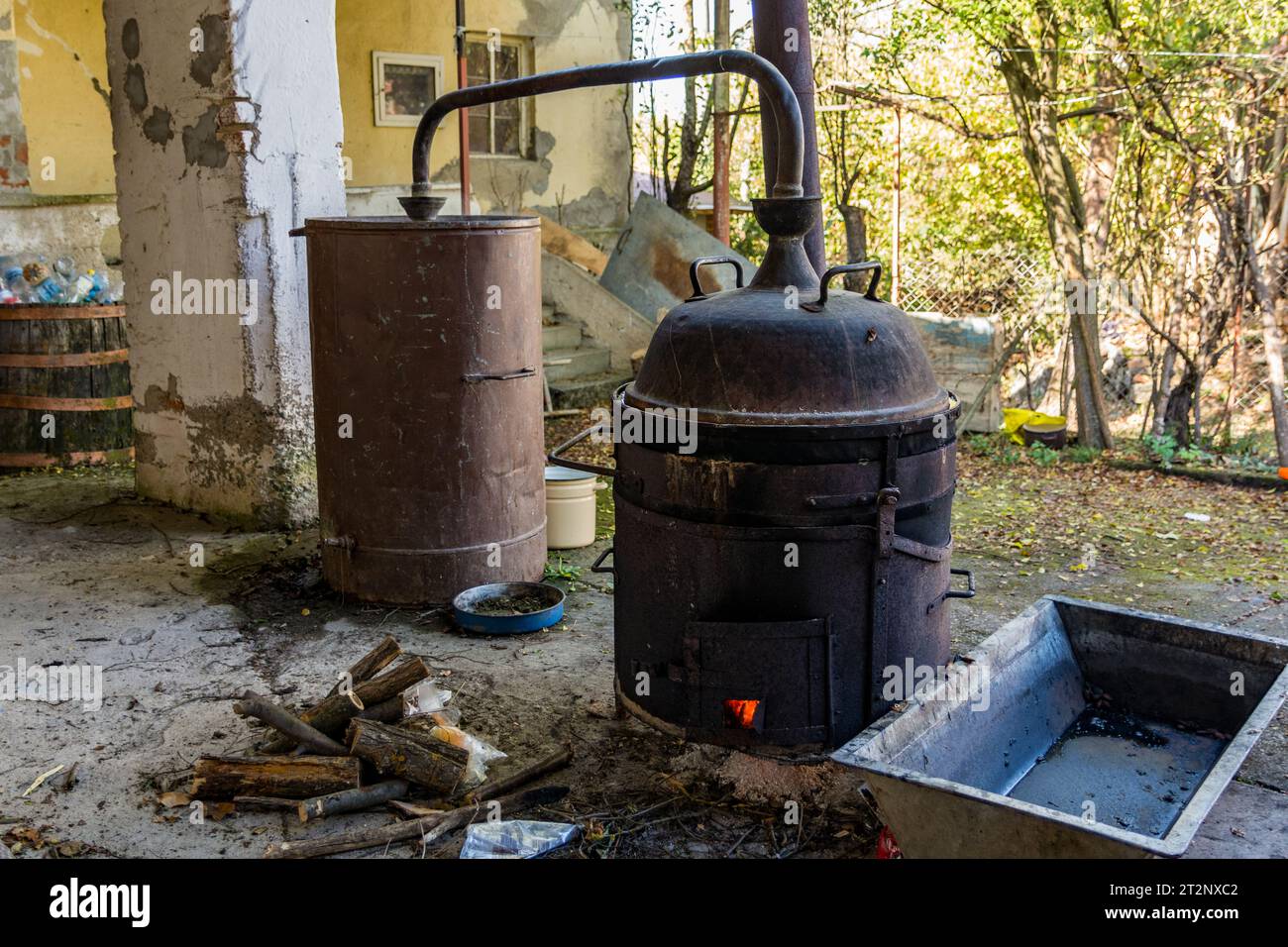 La pentola di distillazione, un elemento chiave nel processo di produzione di bevande alcoliche, si trova in un umile cortile rurale Foto Stock