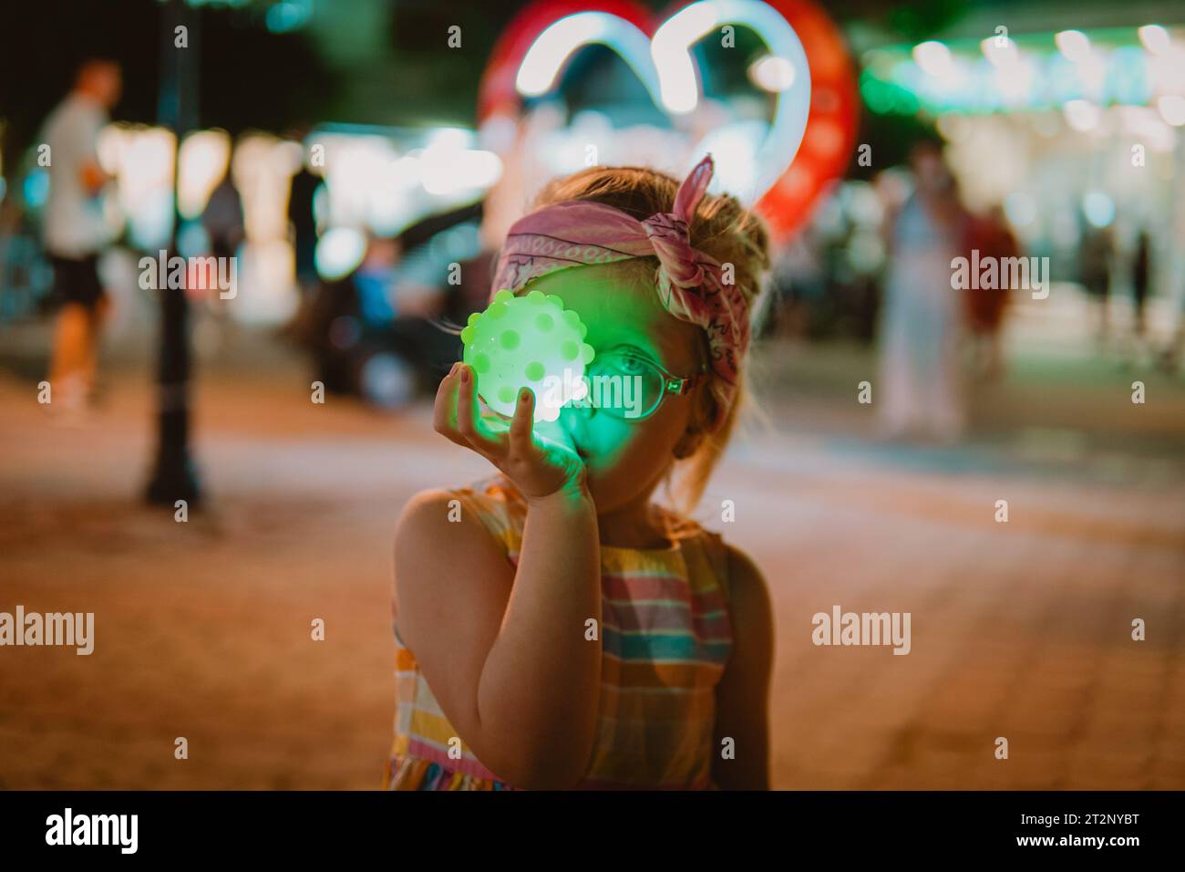 Bambina che gioca con una palla colorata Foto Stock