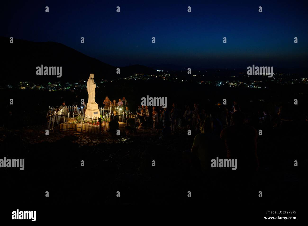 Statua della Vergine Maria, la Regina della Pace, sul Monte Podbrdo di notte circondato da pellegrini in preghiera. Medjugorje, Bosnia-Erzegovina. Foto Stock