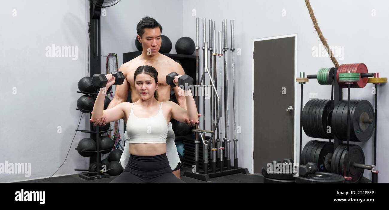 Gli appassionati di fitness si sudano in palestra, motivandosi a vicenda con un allenamento intenso e dedizione. Foto Stock