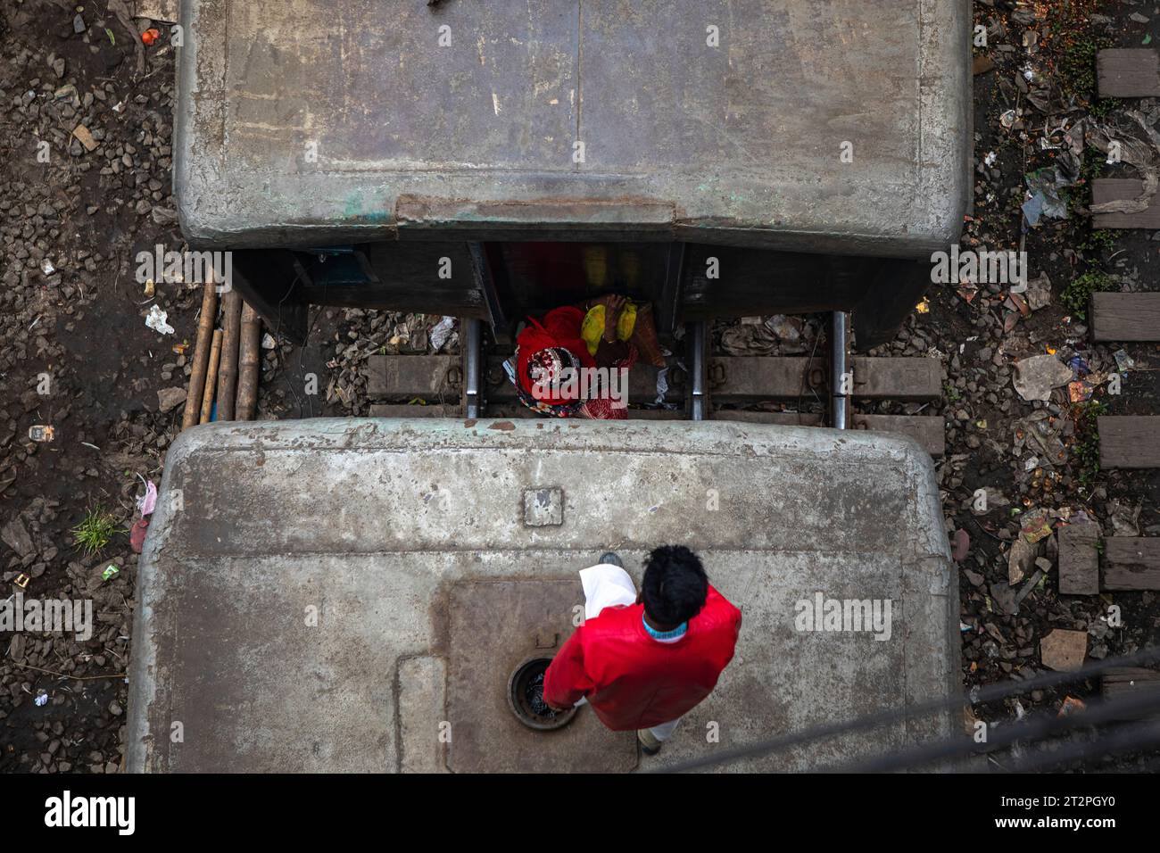 I passeggeri a basso reddito rischiano la vita viaggiando sul tetto e tra le carrozze di un treno in movimento a Dacca, Bangladesh. Foto Stock