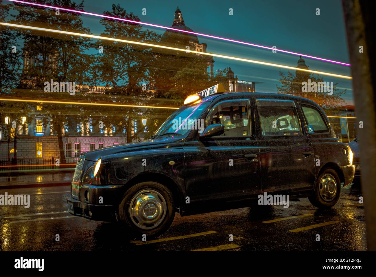 Taxi nero in Irlanda del Nord durante una notte piovosa Foto Stock