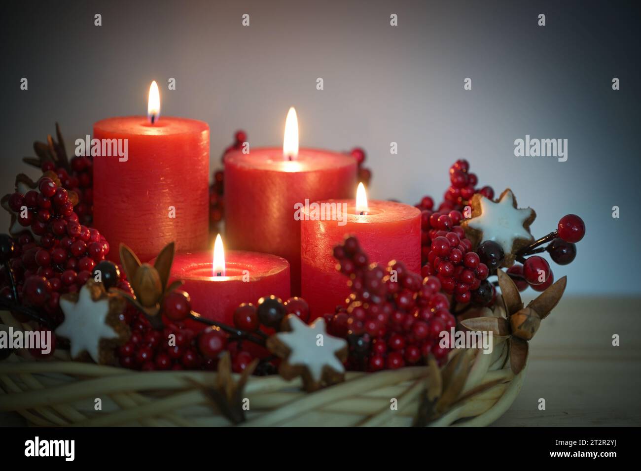 Corona dell'avvento di vimini di salice con quattro candele rosse accese, biscotti e frutti di bosco con stella di cannella, decorazioni natalizie per Natale, spazio fotocopie, Foto Stock