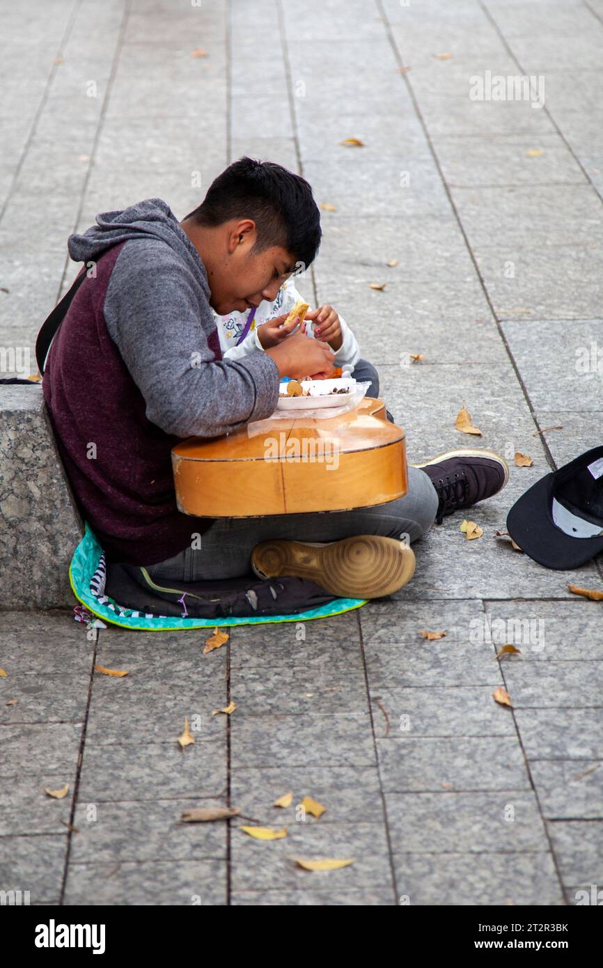 Ragazzo e fratello mangiano la chitarra sul marciapiede di Avenida Presidente Masaryk nel quartiere Polanco di città del Messico, Messico Foto Stock