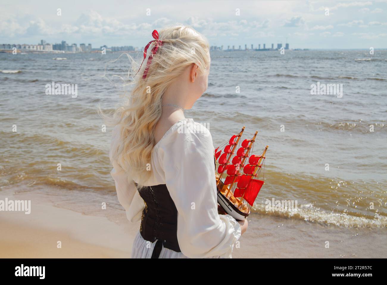 Giovane donna felice che guarda all'orizzonte sulla spiaggia del mare Foto Stock