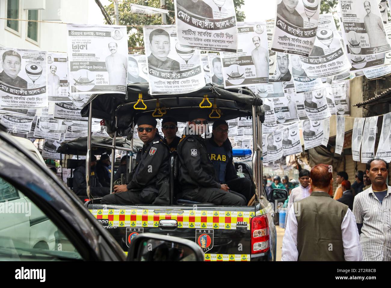 I membri del Rapid Action Battalion (RAB) pattugliano le strade durante le elezioni della Dhaka City Corporation a Dhaka, Bangladesh. Foto Stock