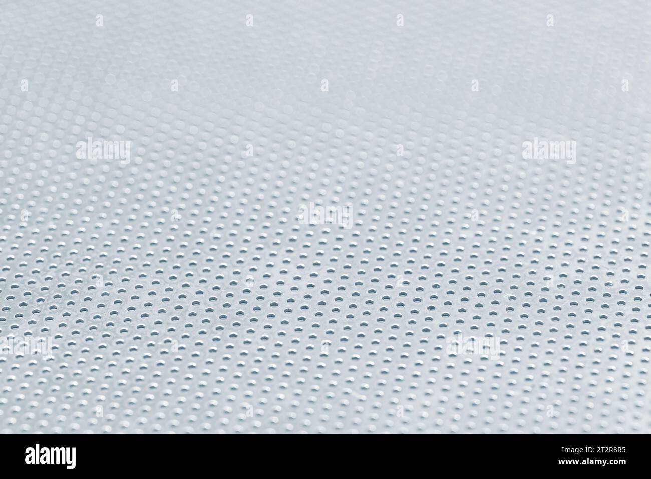 Sfondo astratto di una lamiera forata in acciaio inox. Full frame Foto Stock