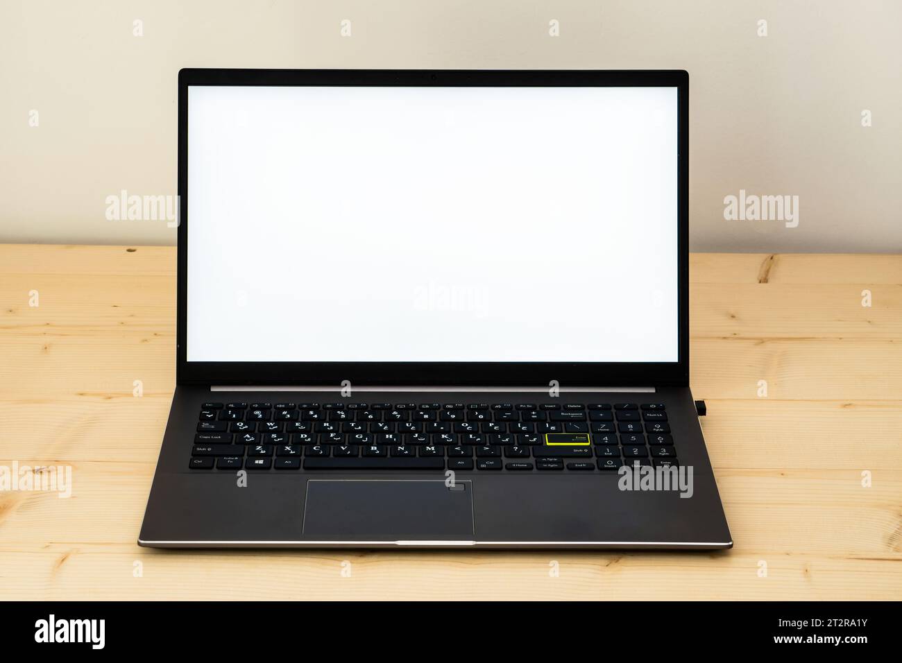 Una foto di un computer portatile su una scrivania di legno che mostra uno schermo vuoto. Foto Stock