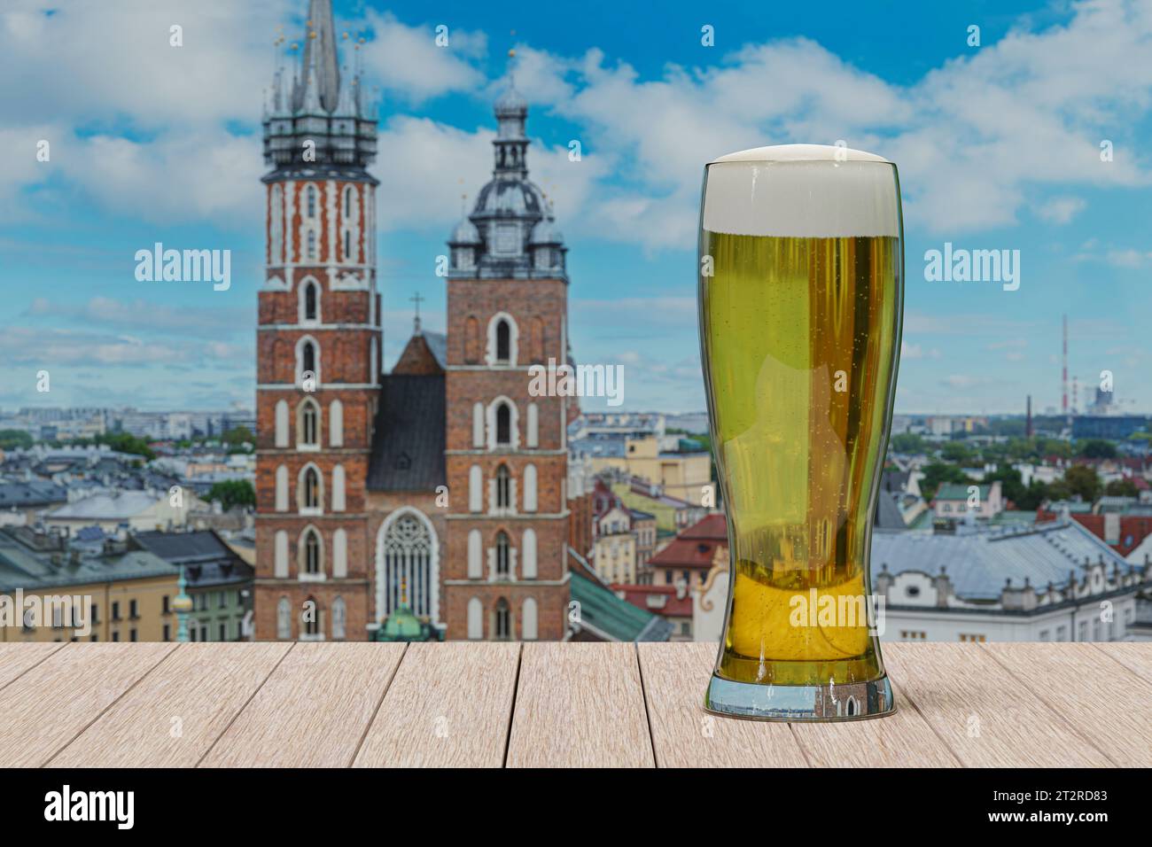 Un bicchiere di birra leggera sul tavolo di fronte al St Basilica di Maria a Cracovia, Polonia Foto Stock