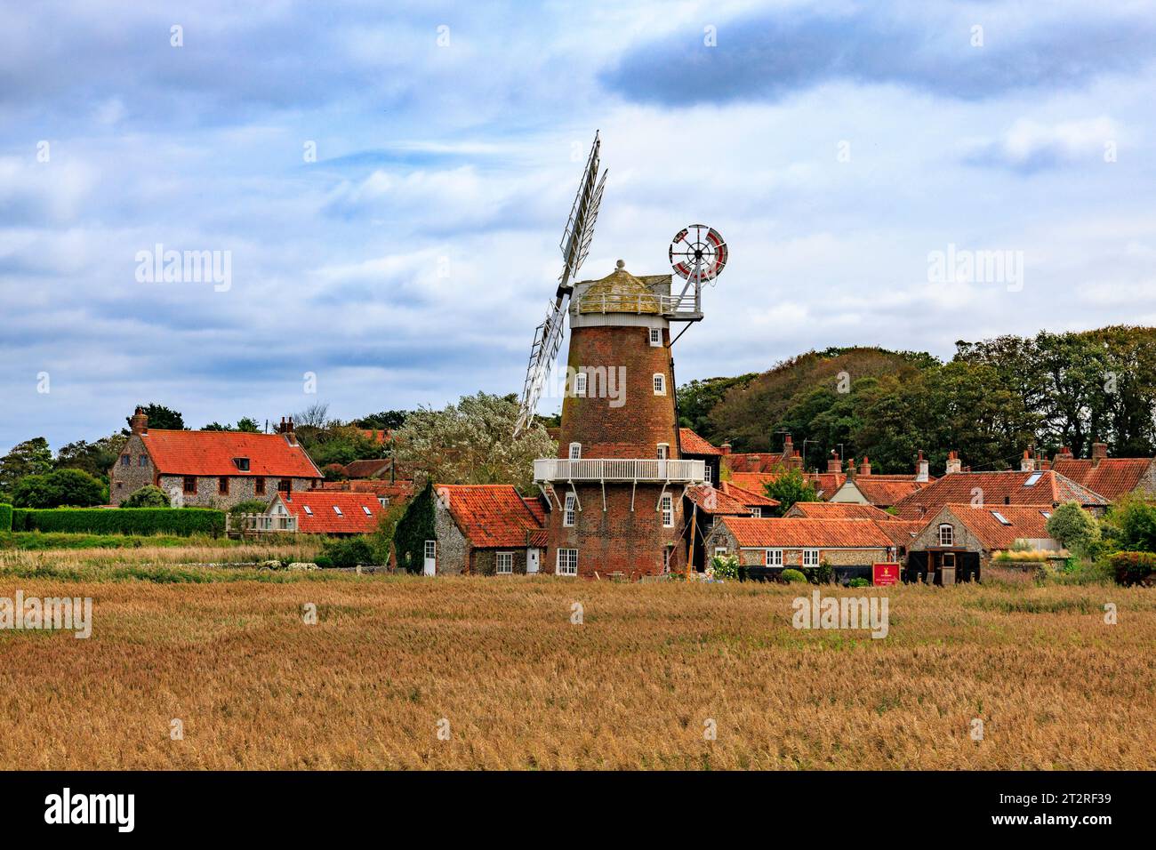 Lo storico mulino a vento a torre classificato di grado II a Cley Next the Sea, visto attraverso la riserva naturale di Cley Marshes, è ora una pensione, Norfolk, Inghilterra, Regno Unito Foto Stock