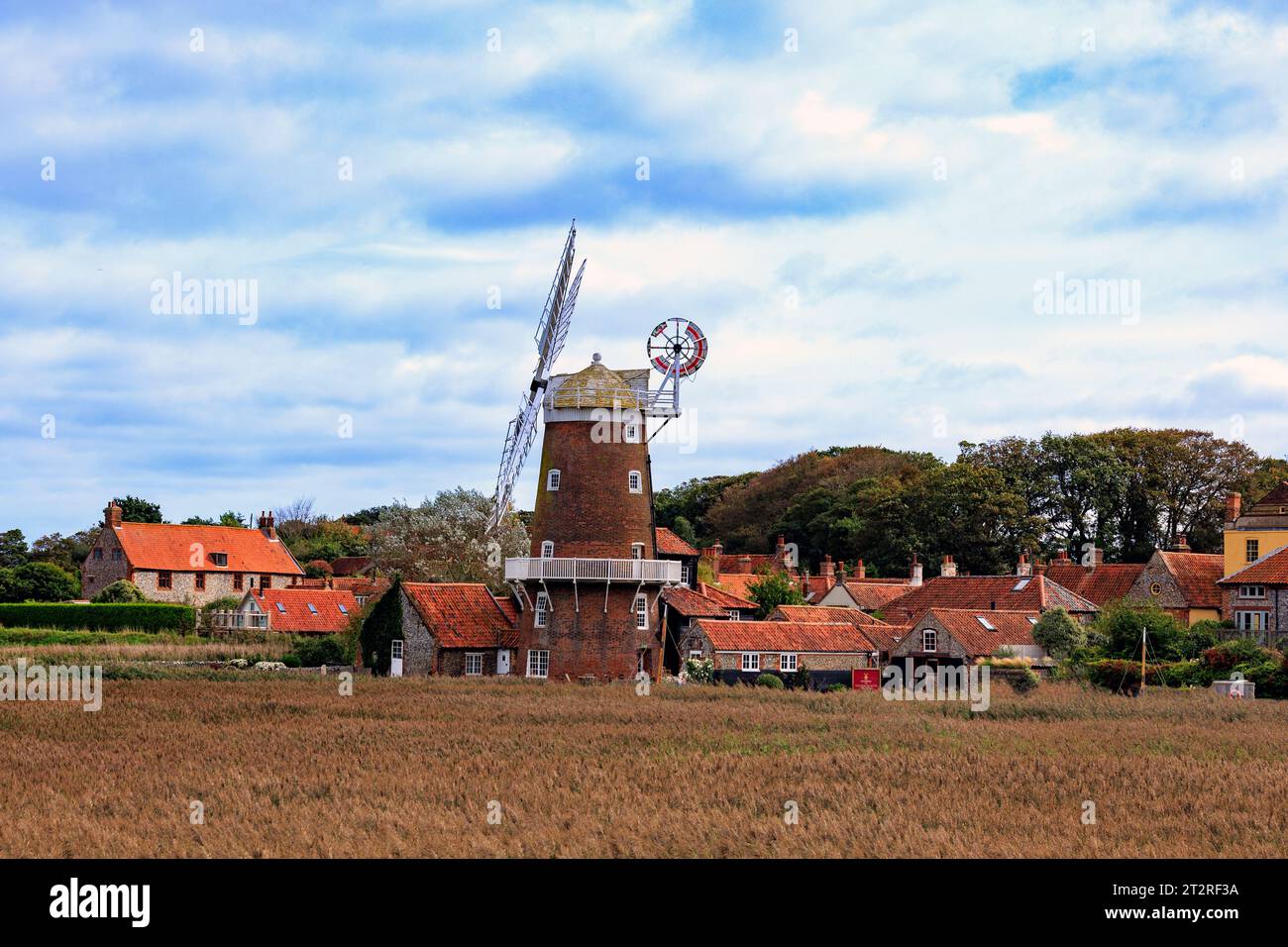 Lo storico mulino a vento a torre classificato di grado II a Cley Next the Sea, visto attraverso la riserva naturale di Cley Marshes, è ora una pensione, Norfolk, Inghilterra, Regno Unito Foto Stock