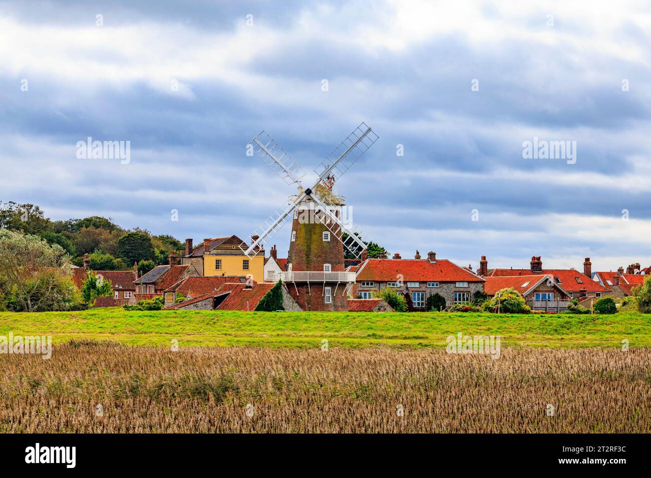 Lo storico mulino a vento a torre classificato di grado II a Cley Next the Sea, visto attraverso la riserva naturale di Cley Marshes, è ora una pensione, Norfolk, Inghilterra, Regno Unito Foto Stock