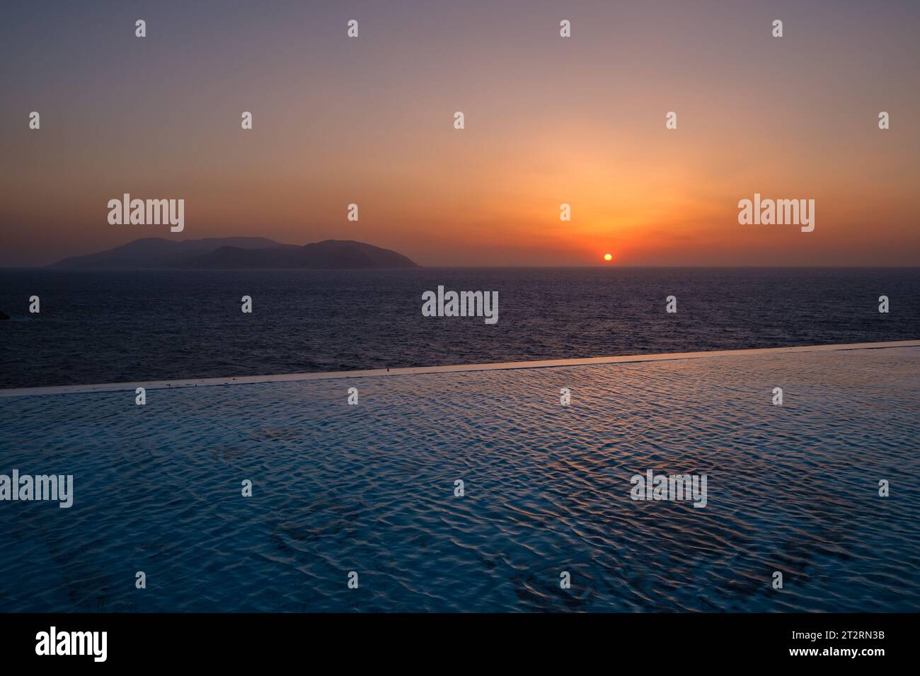 Vista panoramica di una piscina con vista sul Mar Egeo e un tramonto mozzafiato a iOS Grecia Foto Stock