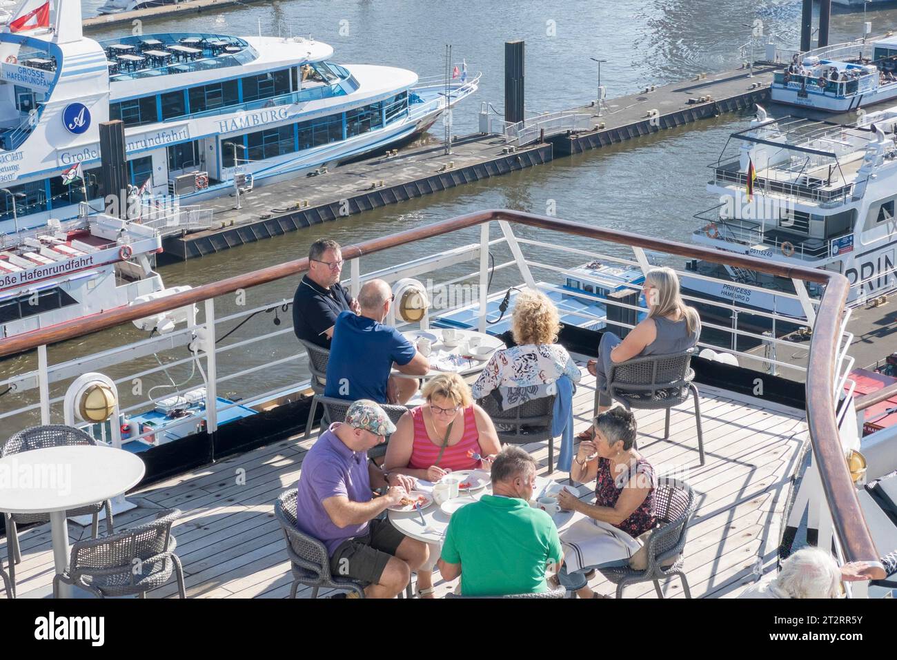 I passeggeri seduti ai tavoli sul Lido Deck della nave da crociera Vasco da Gama ormeggiavano presso l'Ueberseebruecke nel porto di Amburgo Foto Stock