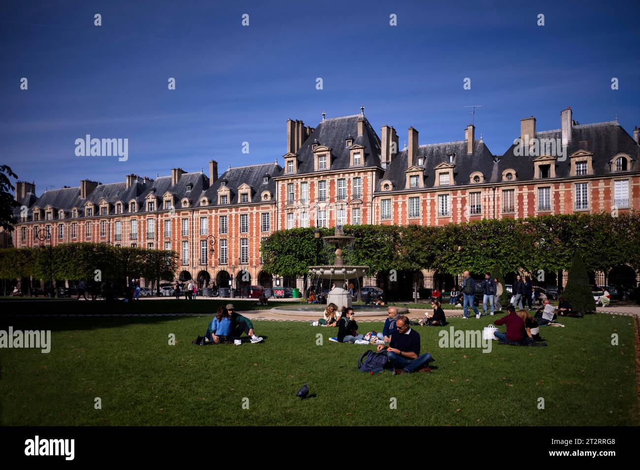 Le persone si rilassano, si rilassano, si trovano in un parco, in Place des Vosges, Square Louis XIII, quartiere ebraico Marais, Village St Paul, Parigi, Francia Foto Stock