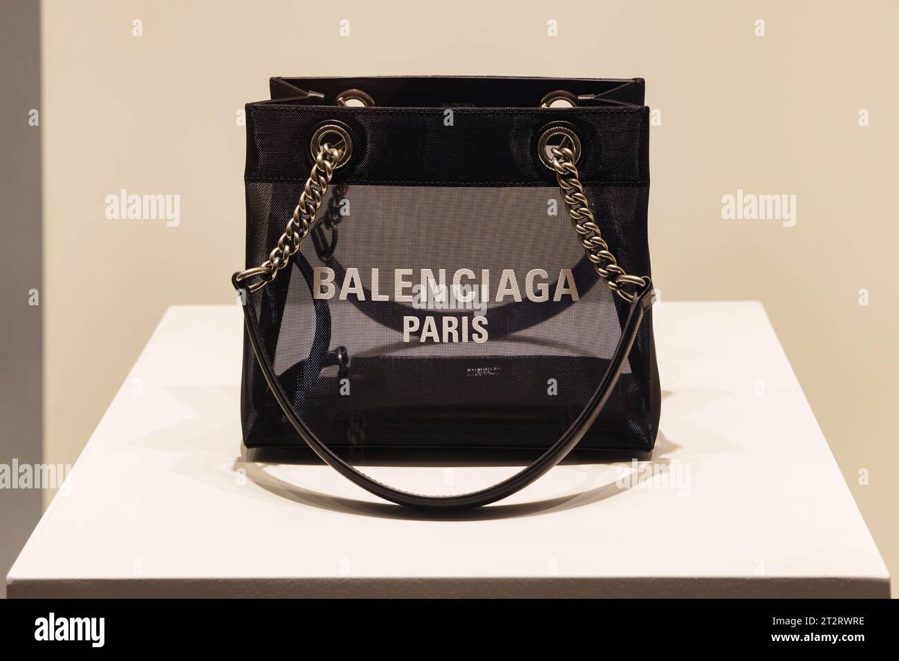 Osaka, Giappone - 13 aprile 2023: Borsa di lusso in una finestra illuminata di un negozio Balenciaga di notte a Osaka. Balenciaga è una moda di lusso spagnola Foto Stock