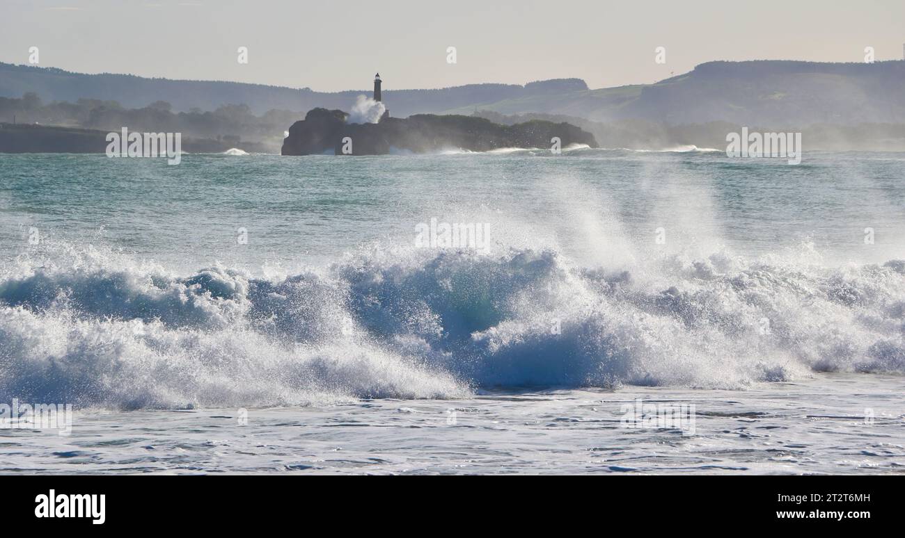 Isola di Mouro una piccola isola disabitata all'ingresso della baia con forti onde in una soleggiata mattinata autunnale Sardinero Santander Cantabria Spagna Foto Stock