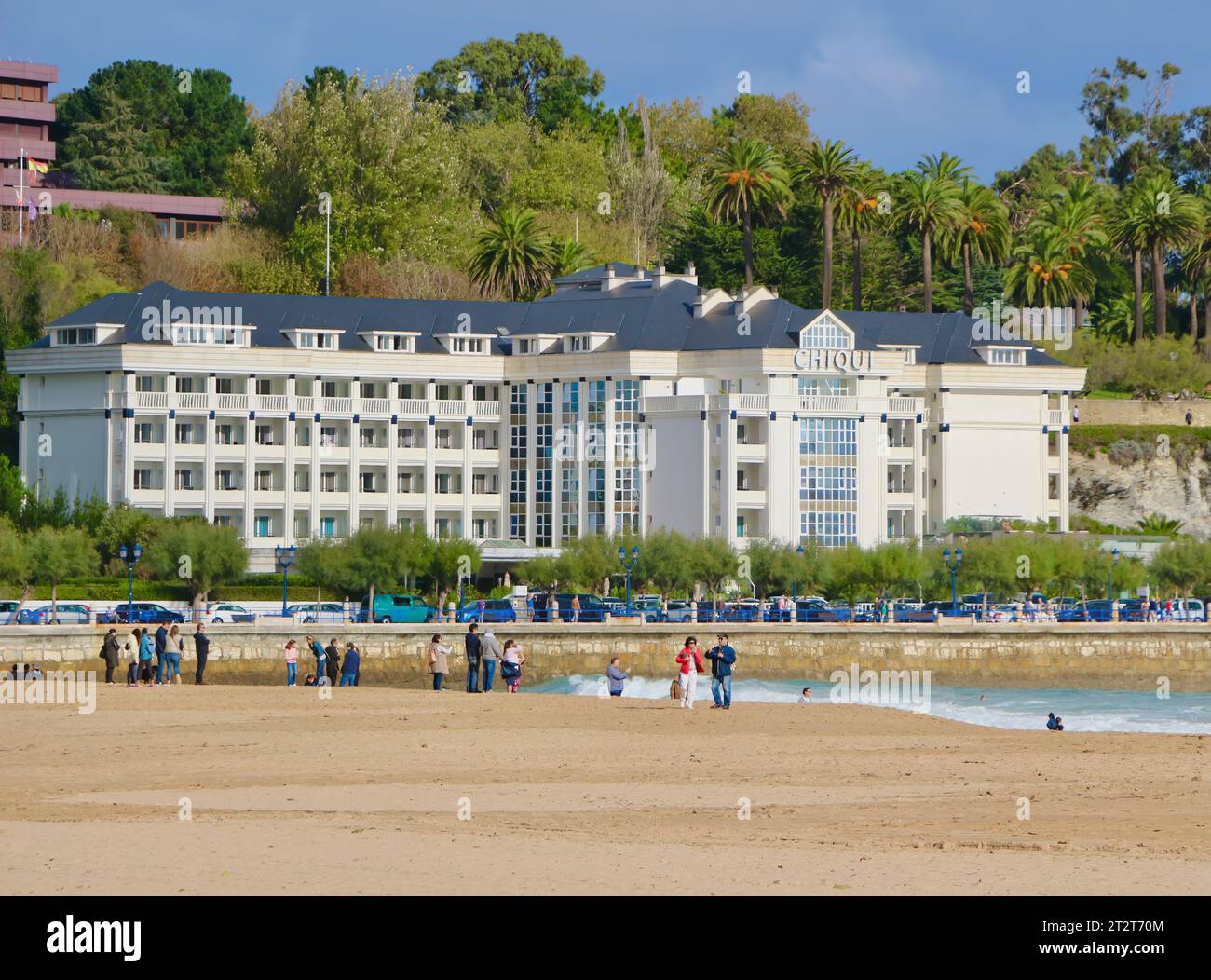 L'Hotel Chiqui con gente che cammina sulla spiaggia in una fresca e ventosa mattinata autunnale Sardinero Santander Cantabria Spagna Foto Stock