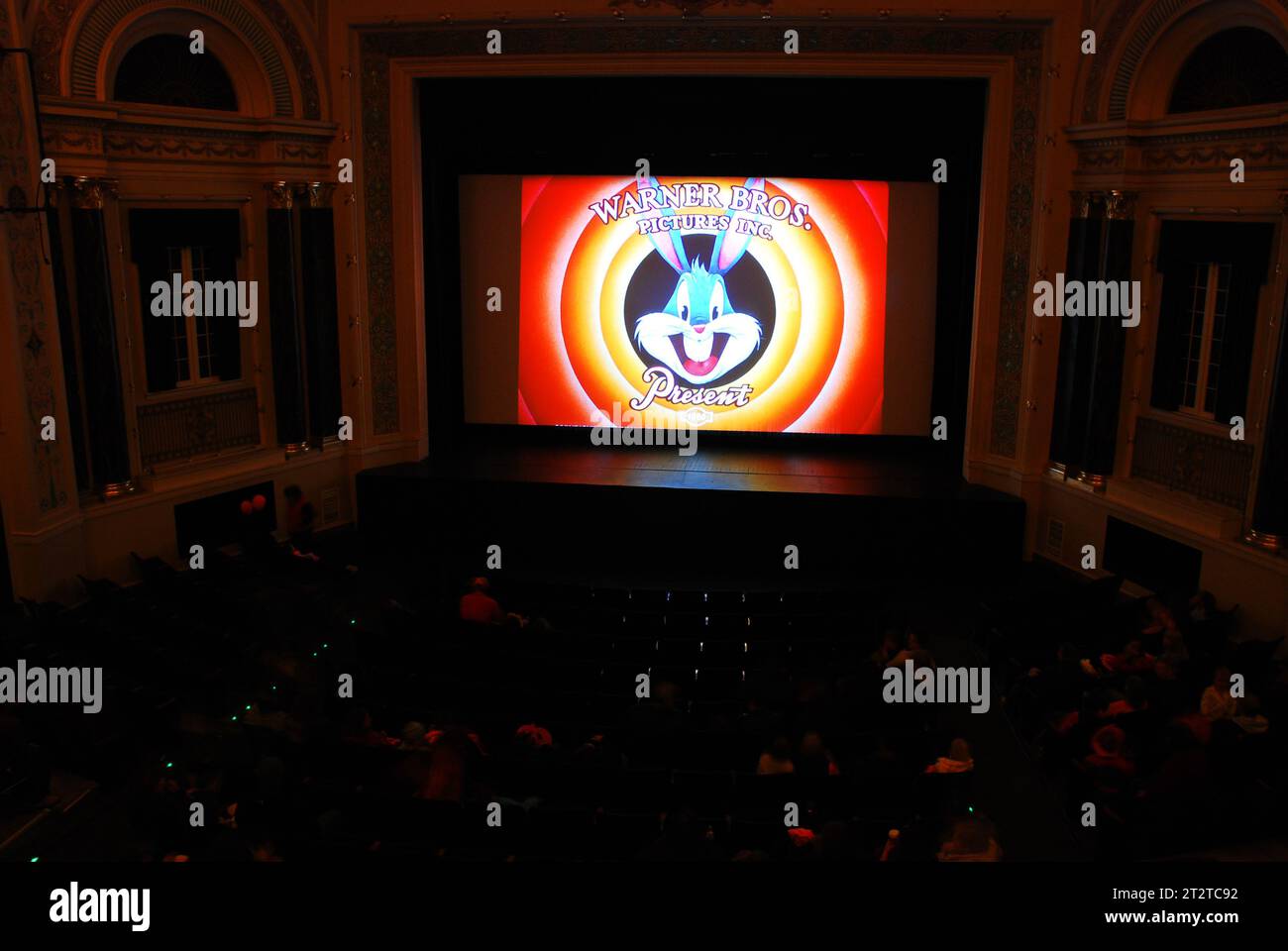 Una folla di cinema si diverte con un Bugs Bunny Looney Tunes Warner Brothers Cartoon mentre aspetta l'inizio del film Foto Stock