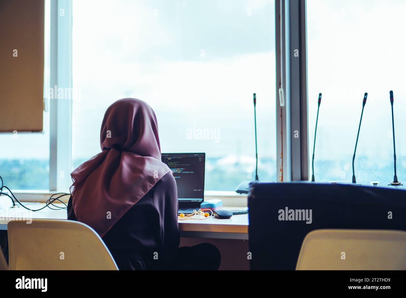 Una giovane donna sviluppatrice di IT è profondamente concentrata sul suo lavoro mentre digita con diligenza il suo notebook Foto Stock