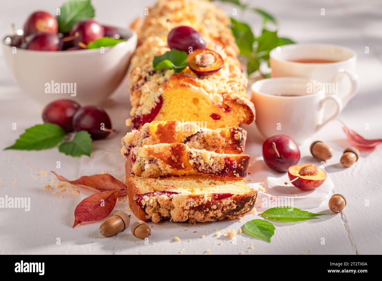 Gustosa torta di lievito di prugne servita con tè e limone. Torta al lievito servita con tè. Foto Stock