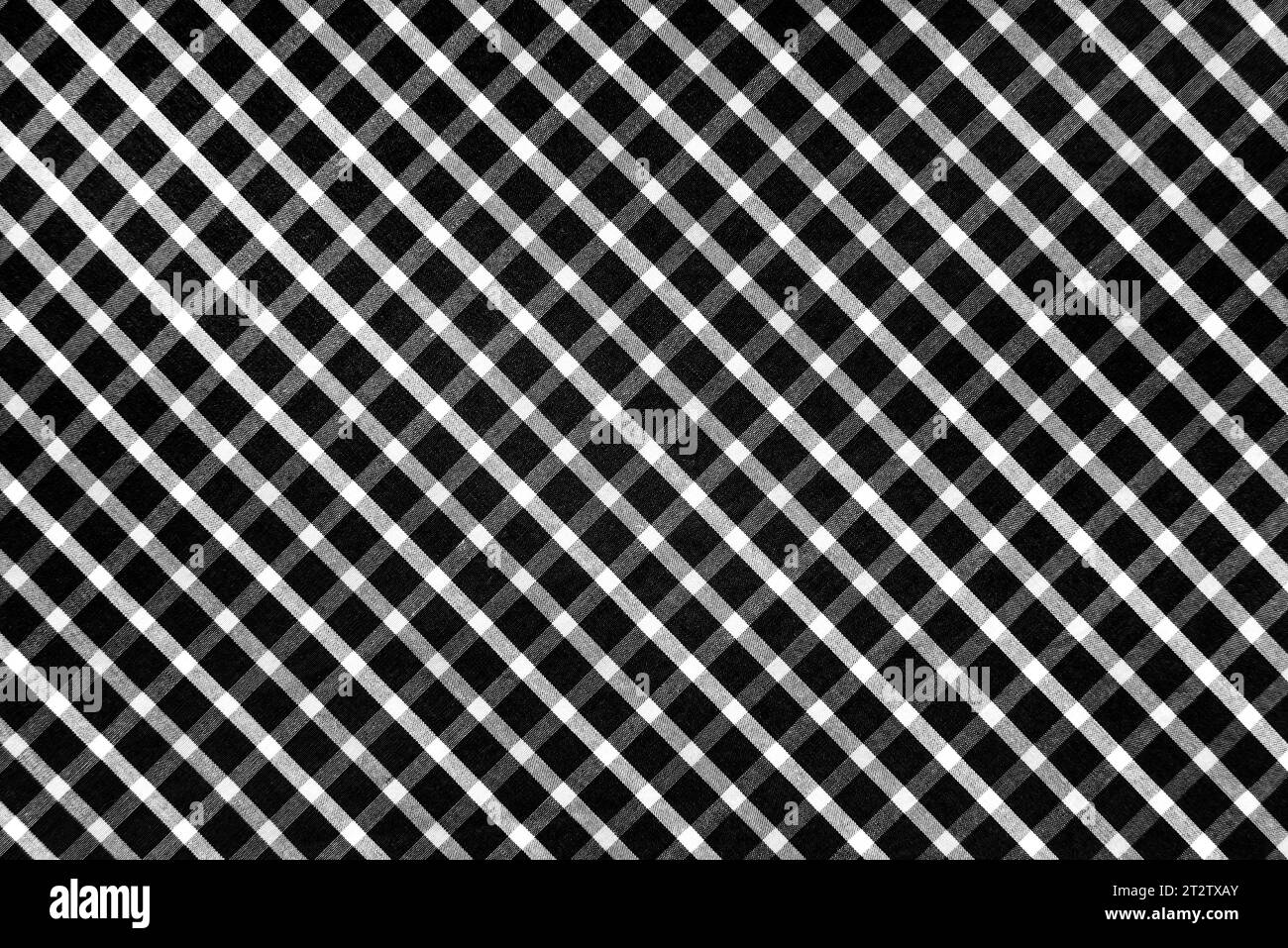 Trama del tessuto a scacchi con quadratini bianchi e neri. Sfondo in tessuto bianco e nero a scacchi. Materiale sartoriale scozzese. Foto Stock