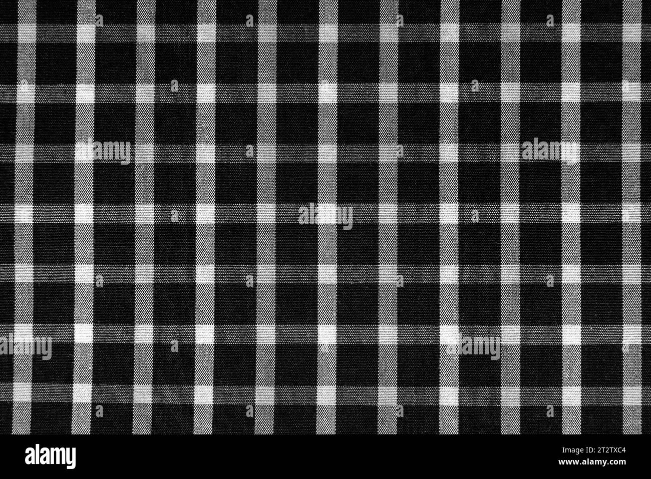 Trama del tessuto a scacchi con quadratini bianchi e neri. Sfondo in tessuto bianco e nero a scacchi. Materiale sartoriale scozzese. Foto Stock