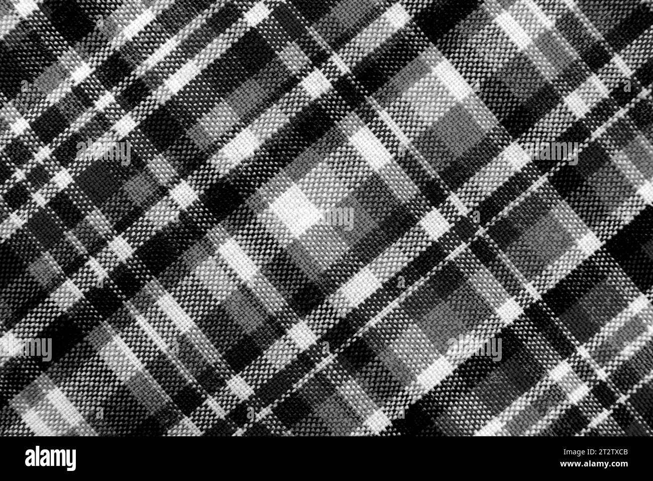 Trama del tessuto a scacchi con quadratini bianchi e neri. Sfondo in tessuto bianco e nero a scacchi. Materiale sartoriale scozzese. Foto Stock