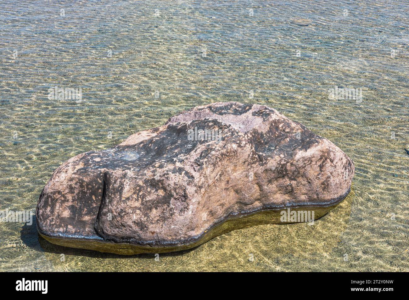 Acqua di fondo vicino alla riva con una riva in pietra Foto Stock