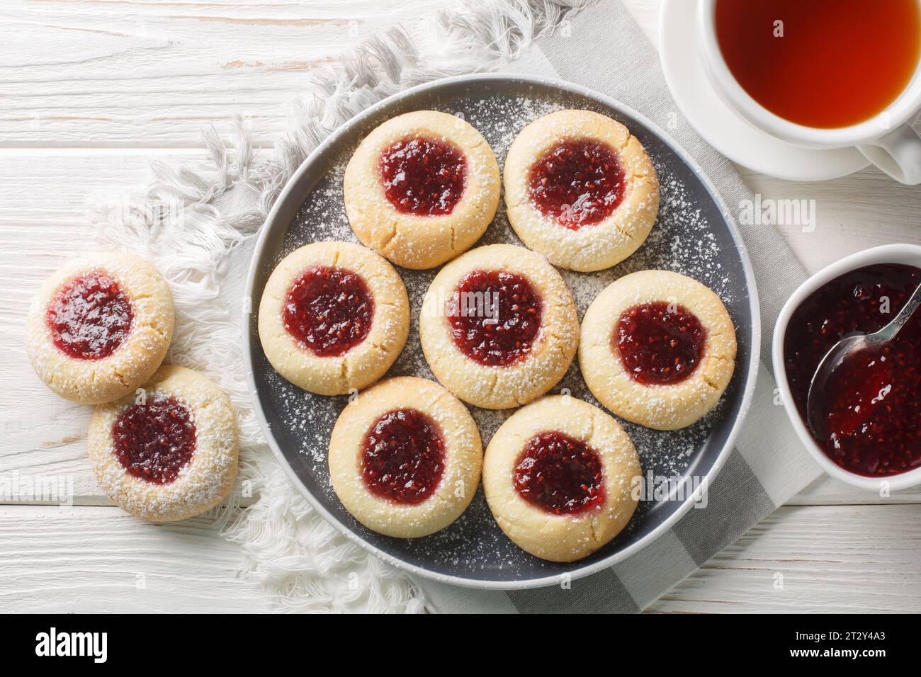 Primo piano sui biscotti Hallongrottor Swedish Thumbprint sul piatto sul tavolo di legno bianco. Vista superiore orizzontale dall'alto Foto Stock