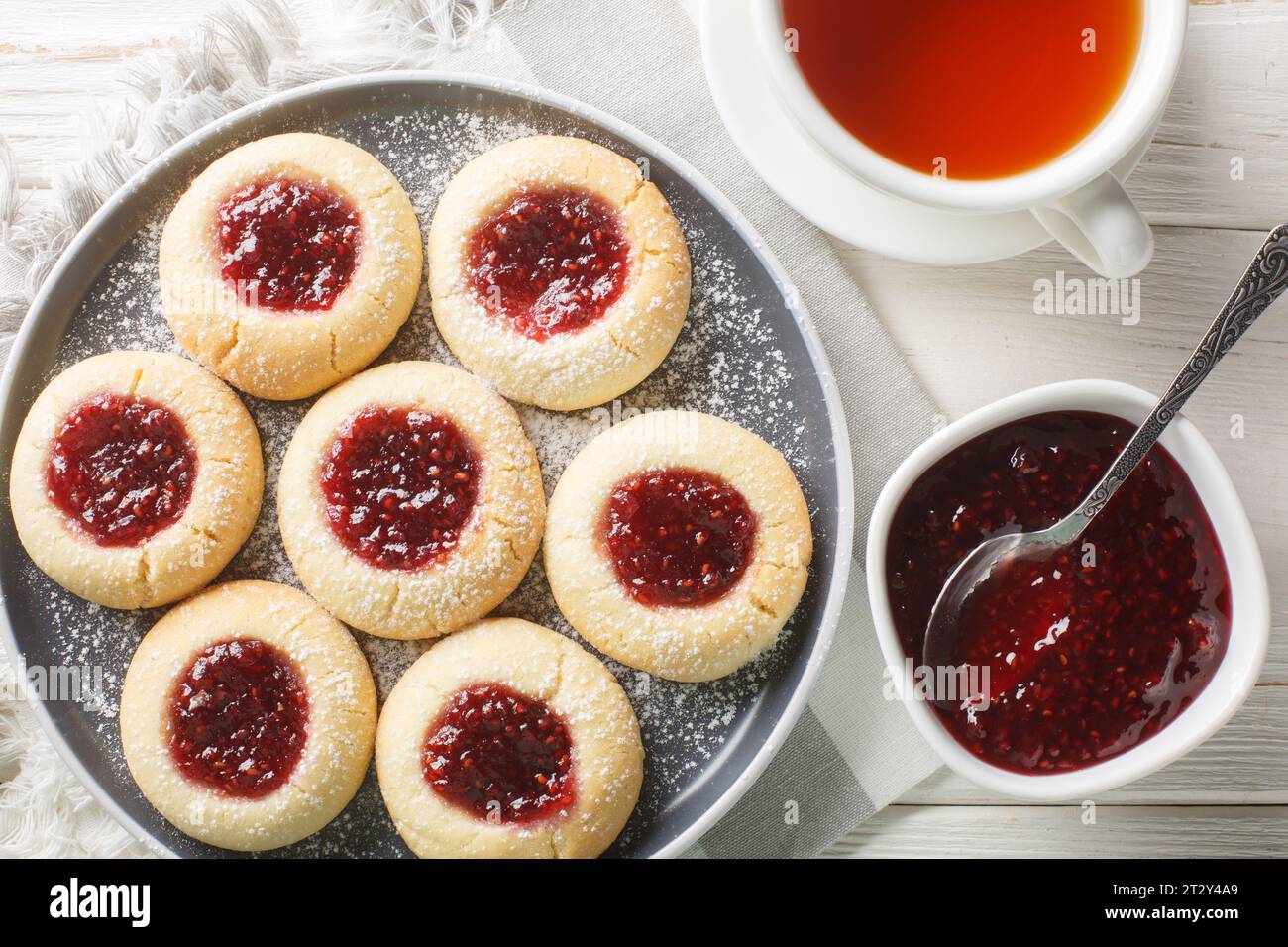 Primo piano dei biscotti di marmellata delle grotte di Hallongrottor o di rapsberry svedesi sul piatto sul tavolo di legno bianco. Vista superiore orizzontale dall'alto Foto Stock