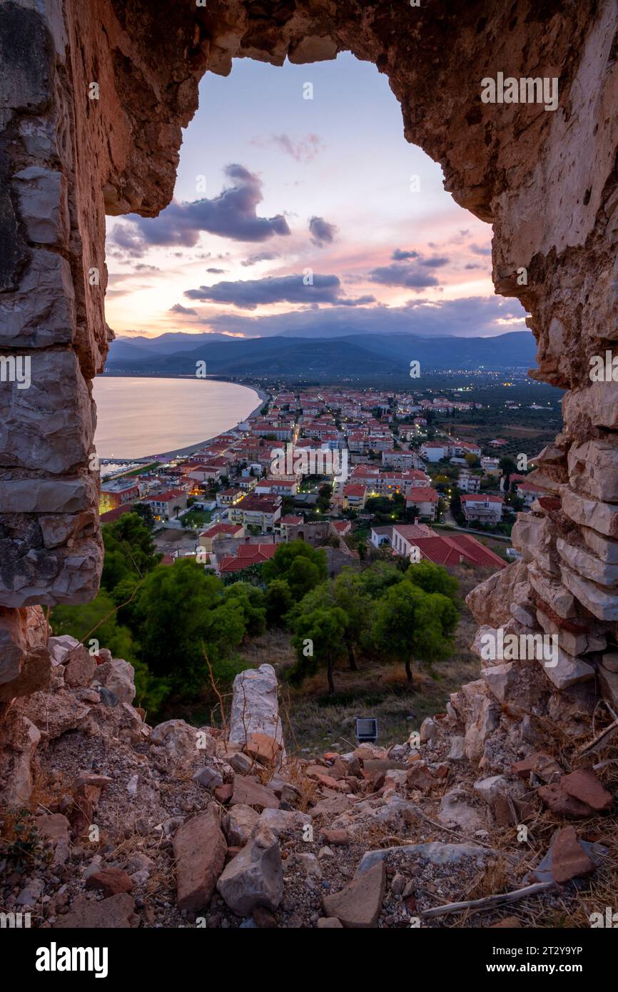 Vista panoramica della città costiera di Paralio Astros al tramonto, attraverso un bastione del castello medievale (XVII sec.) che si affaccia sulla città. Foto Stock