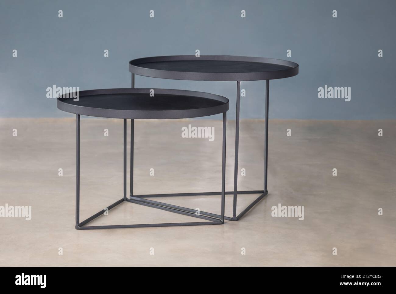 design moderno degli interni con doppio tavolo in metallo su pavimento in cemento lucido Foto Stock