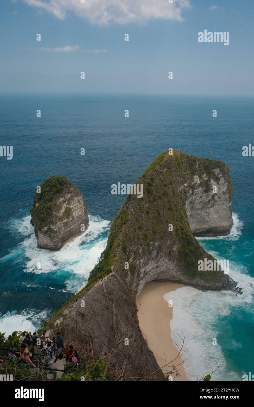 Sali verso una prospettiva più alta e ammira l'incantevole bellezza di Kelingking Beach sotto un cielo nebbioso. Foto Stock