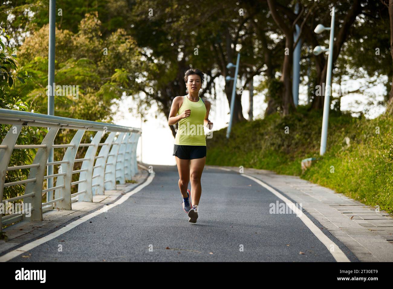 giovane donna asiatica jogger che si esercita all'aperto nel parco cittadino Foto Stock