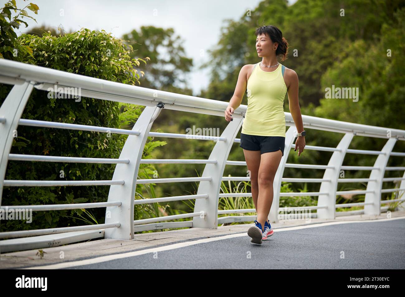 giovane donna asiatica jogger che cammina rilassandosi riposando nel parco cittadino Foto Stock