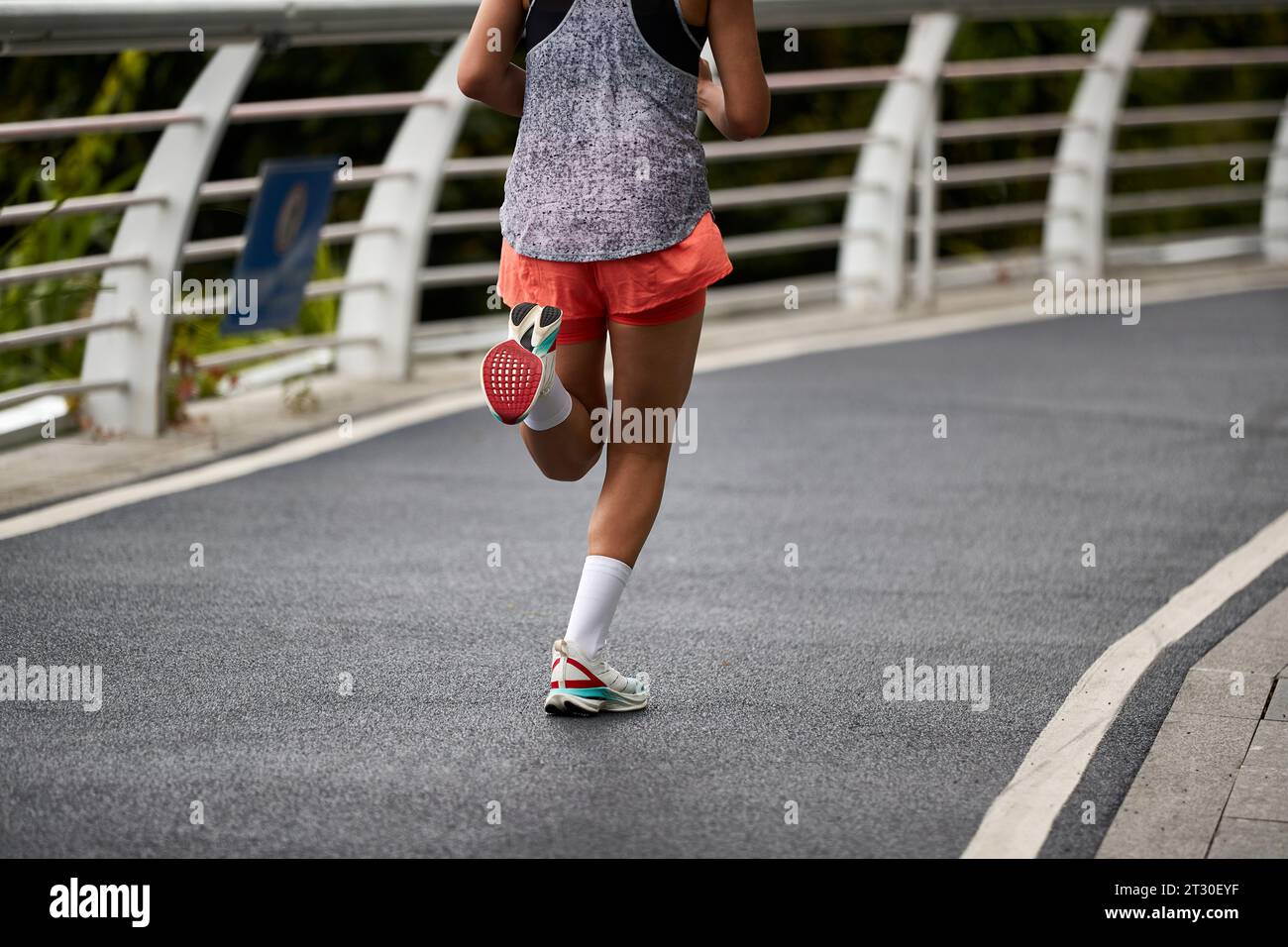 foto ravvicinata di gambe e piedi di una donna asiatica che corre all'aperto Foto Stock