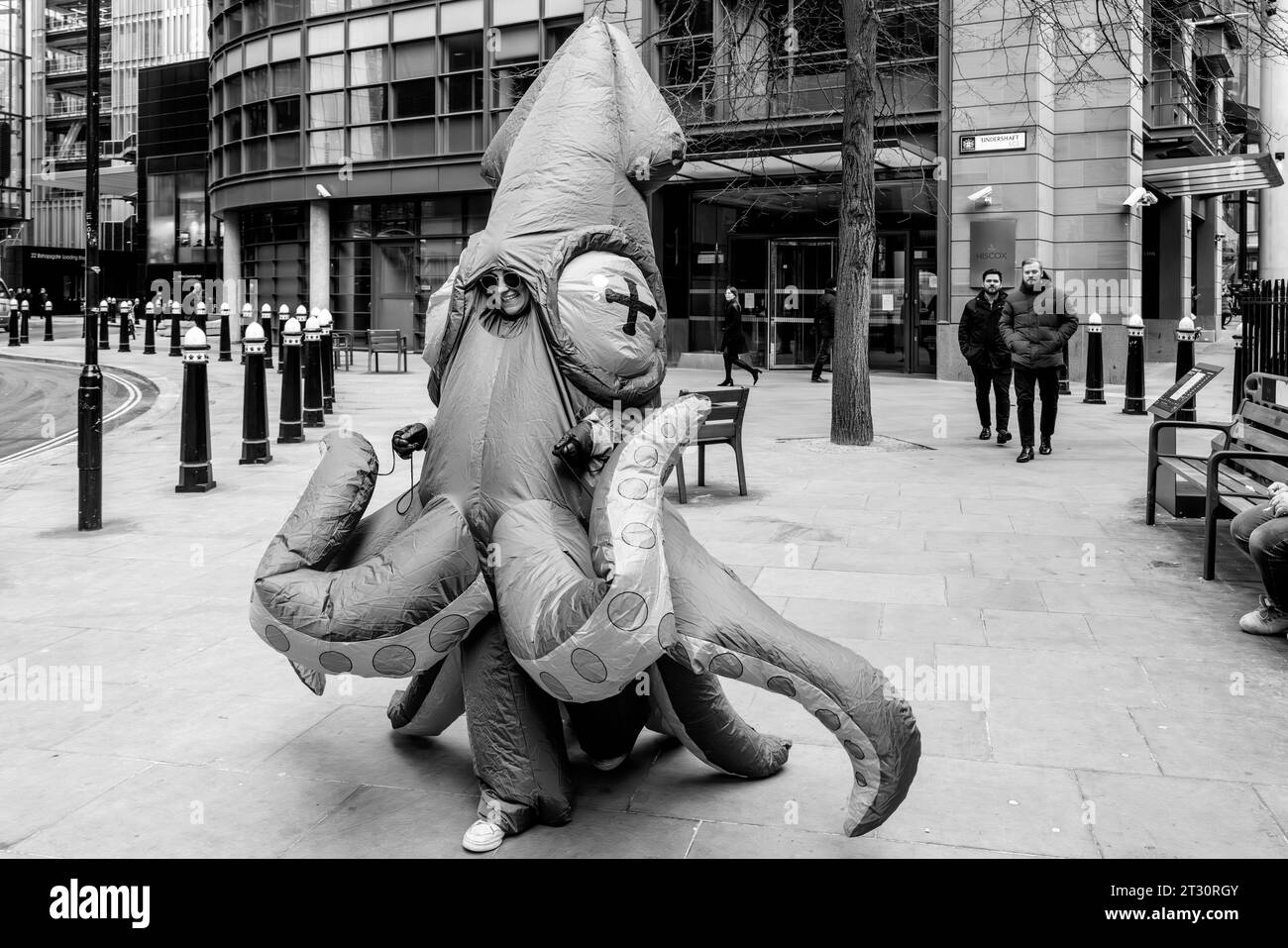 Una giovane donna che indossa un costume Squid camminando attraverso la città di Londra, Londra, Regno Unito. Foto Stock