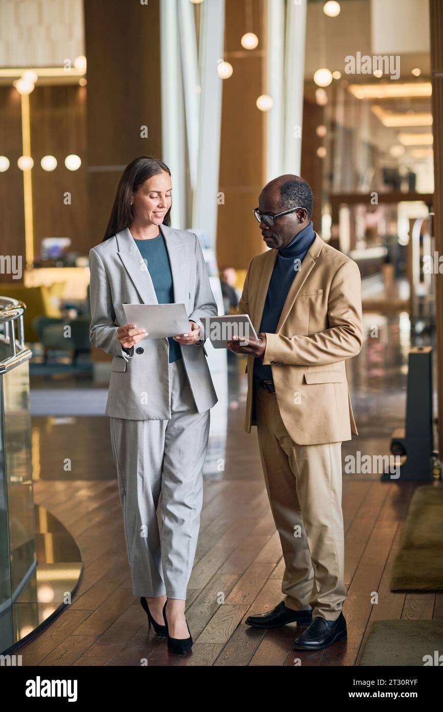 Immagine verticale dei colleghi che discutono di lavoro durante la riunione in hotel Foto Stock