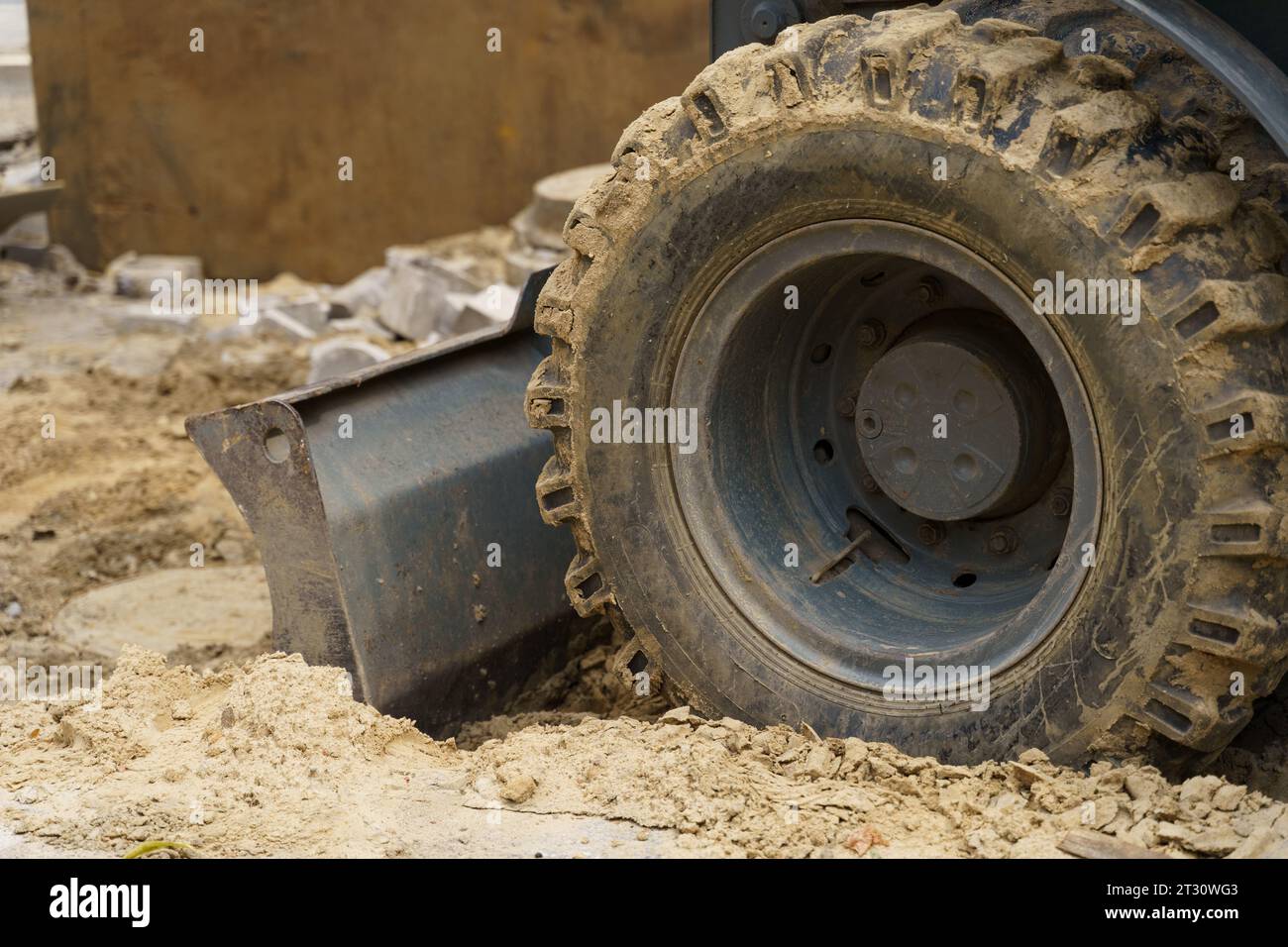 Primo piano dei denti della benna sporchi e della ruota dell'escavatore. Parti di attrezzature per movimento terra. Foto Stock