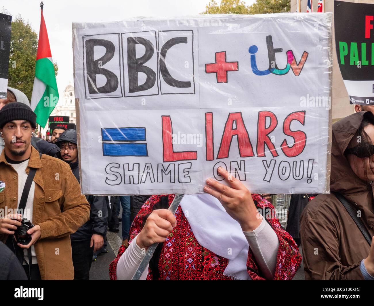 Manifestanti pro-palestinesi a Londra, nel Regno Unito, alla manifestazione della marcia Nazionale per la Palestina fermare la guerra a Gaza, marciare per protestare contro il confict di Israele Palestina sulla Striscia di Gaza. Manifestanti con cartellone pubblicitario Anti BBC e Anti ITV che protestano sulla copertura del conflitto di Gaza sui canali televisivi di notizie del Regno Unito Foto Stock
