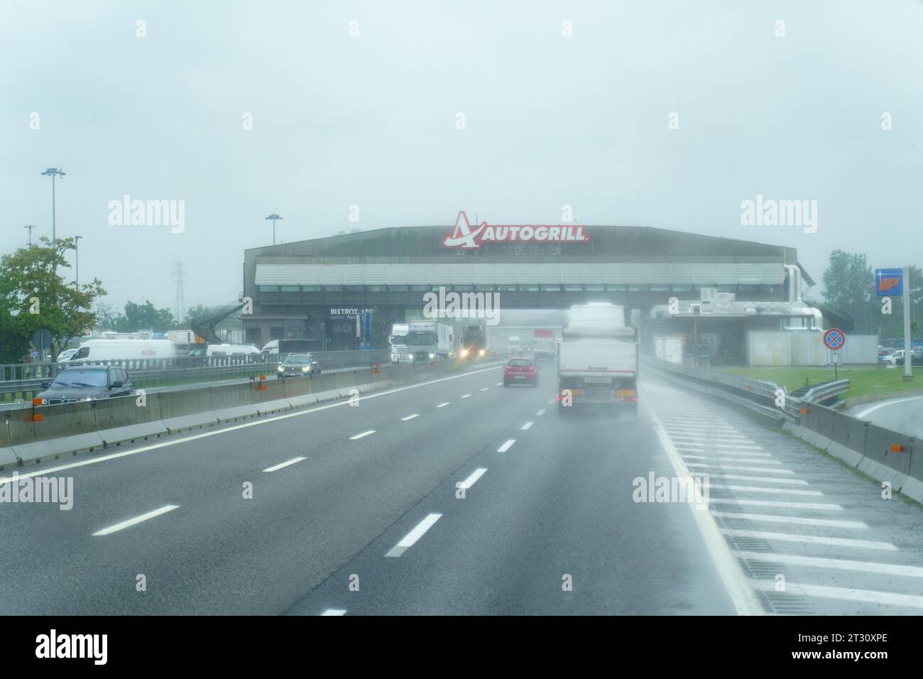 Fontanellato, Italia - 10 maggio 2023: Ristorante e bar Autogrill in una giornata piovosa con cieli cupi su un'autostrada in Italia. Foto Stock