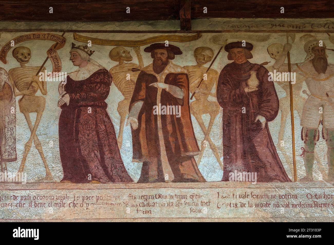 Scheletri sorridenti con una donna e tre uomini, ciascuno forato dalla freccia della morte: Una regina; un uomo barbuto che indossa un cappello piatto rotondo; un uomo che porta un barattolo; e un soldato in armatura. Particolare del fregio rinascimentale Danza Macabra, dipinto nel 1539 da Simone II Baschenis (c. 1495-1555) su una parete esterna della Chiesa di San Vigilio, Pinzolo, Trentino-alto Adige. Il fregio ha didascalie nei dialetti locali e nella lingua compresa dalla gente comune. Foto Stock