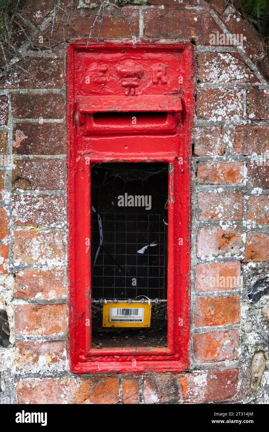 Cassetta postale rossa rotta (e II R) sulla strada di Worthing, West Sussex Foto Stock
