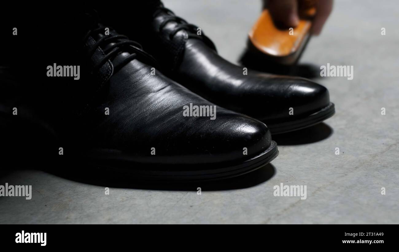 Scarpe classiche nere in pelle cerata. Stock di filmati. Primo piano degli stivali per la pulizia e la lucidatura. Foto Stock