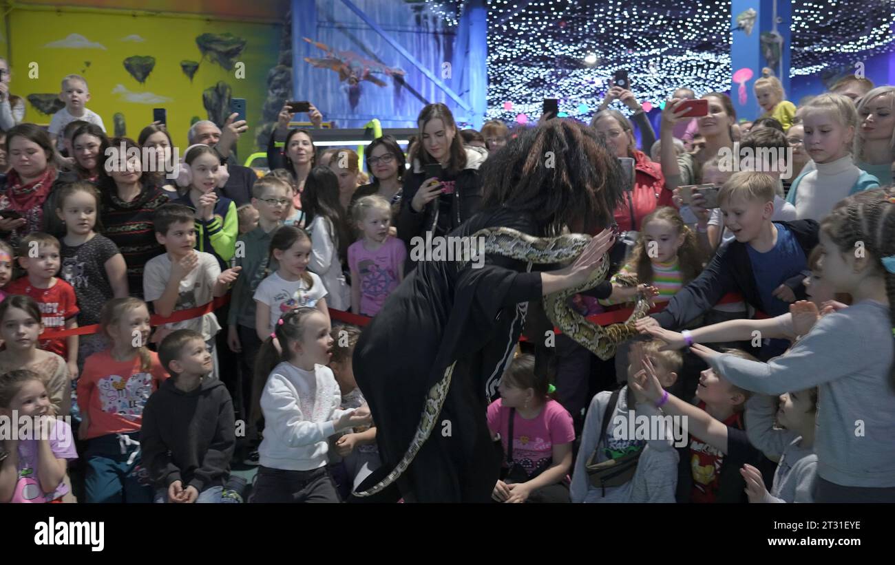 Serbia, Belgrado - 20 giugno 2023: Spettacolo di circo con serpente. Clip. Spettacolo di intrattenimento per bambini con artisti circensi e serpenti. L'uomo dà pitone a Foto Stock